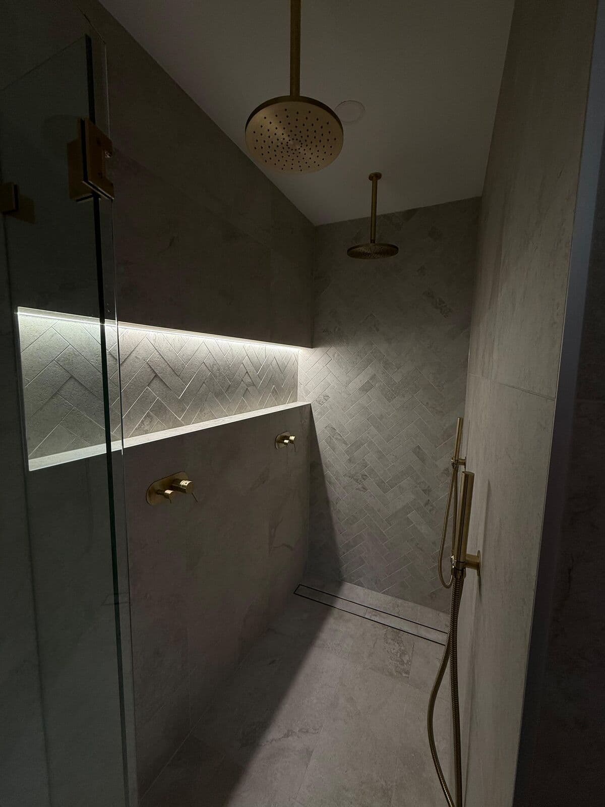 Dark bathroom with strip lighting near the shower