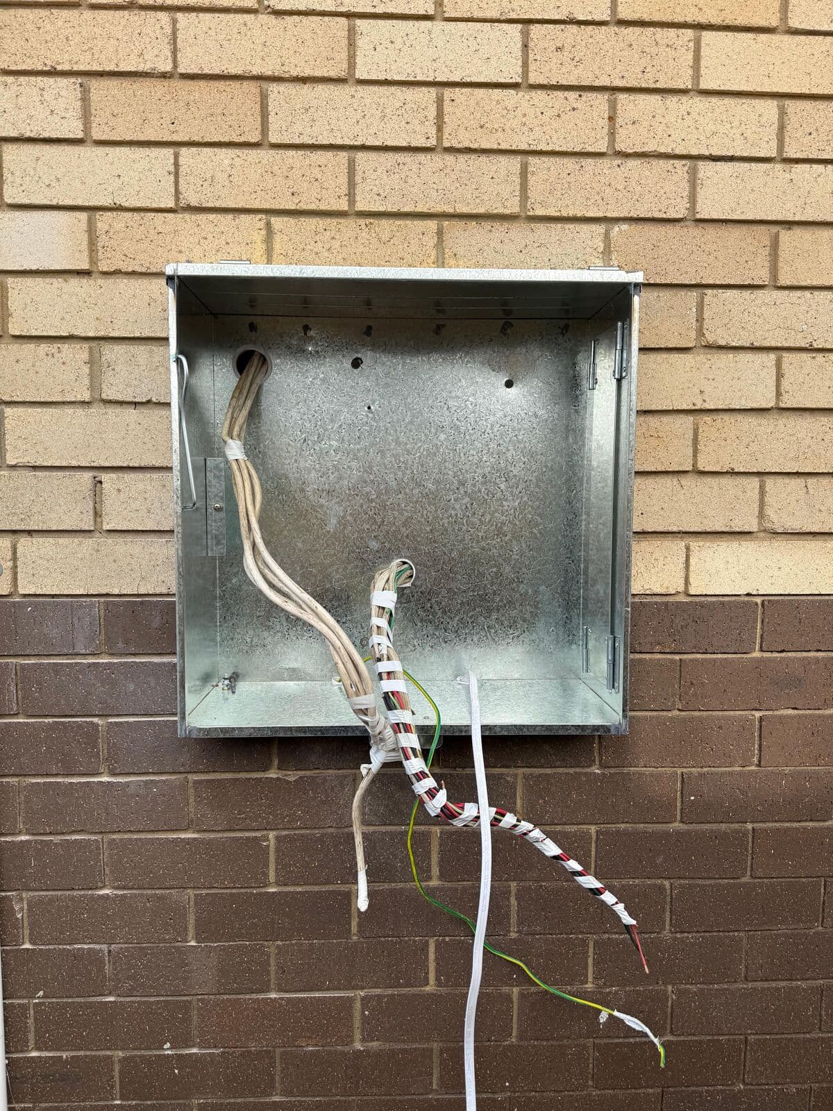 Empty meter box with the existing cables exposed, ready for a new switchboard