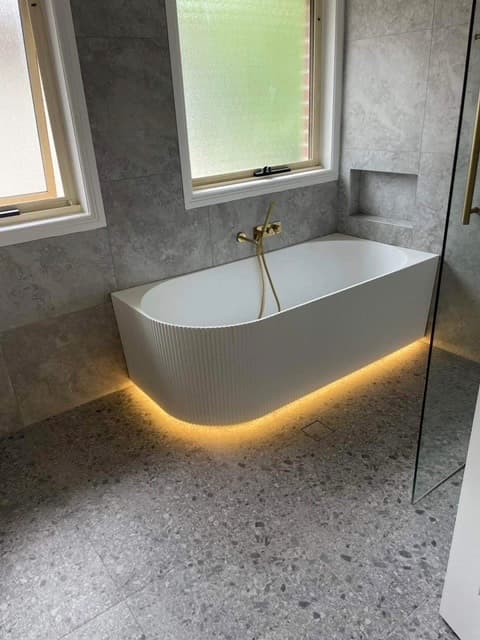 Freestanding bath with lighting around its raised base
