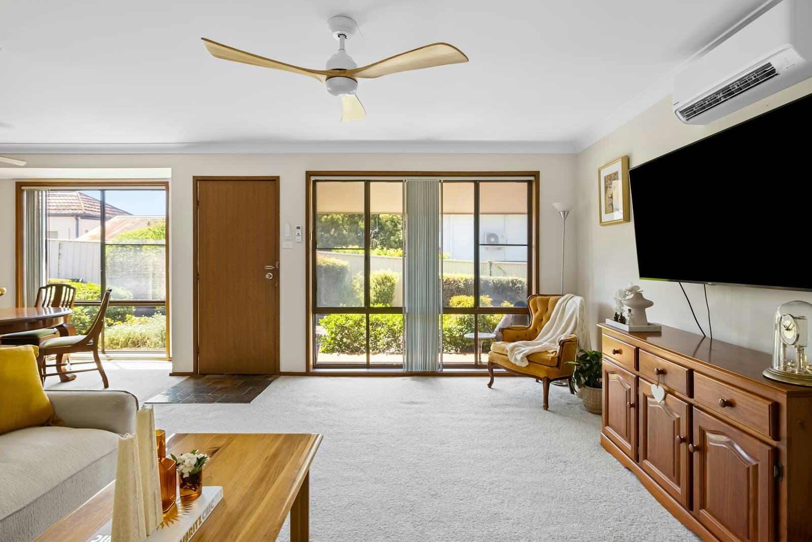 Living room with a three-blade ceiling fan and a split-system air conditioner